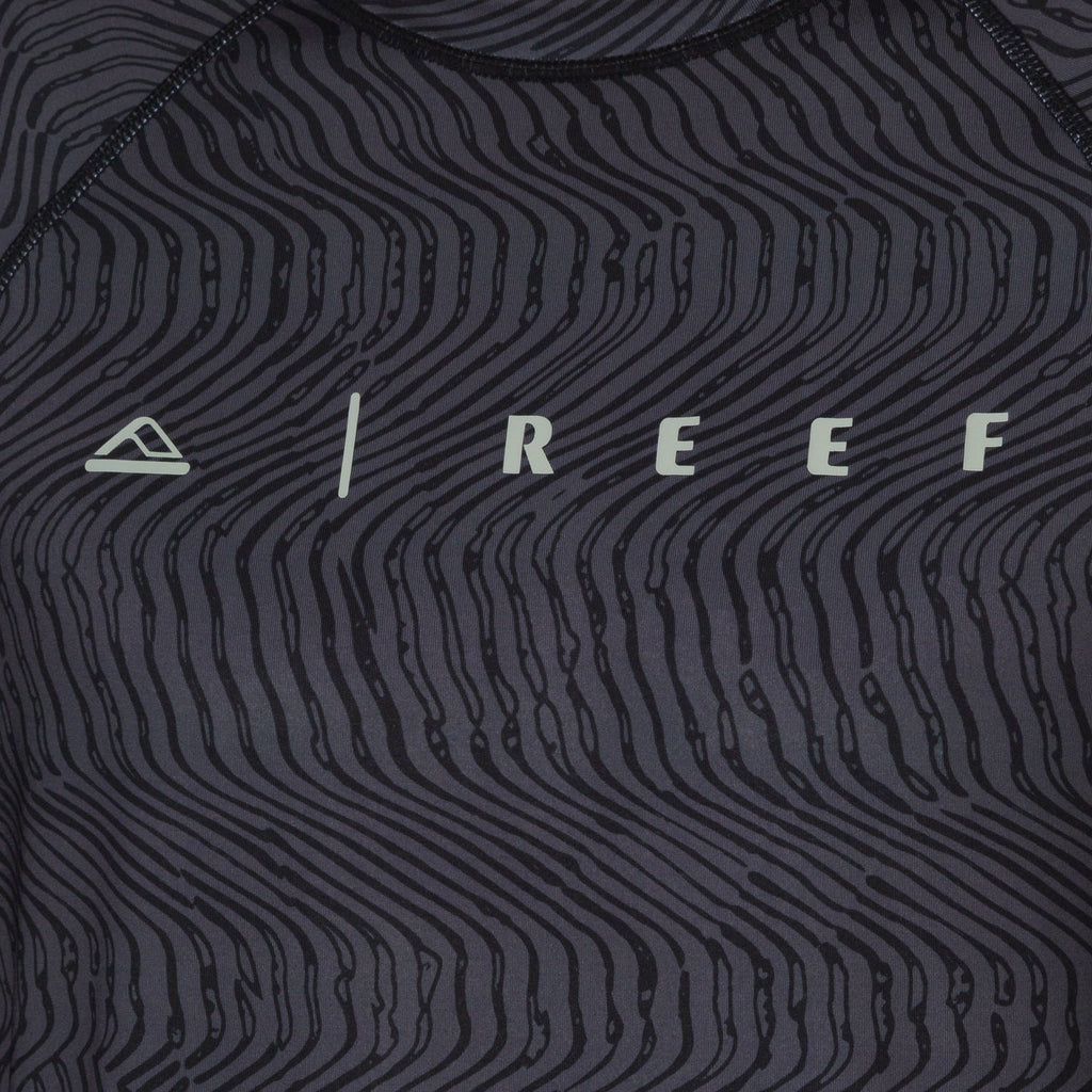 Close-up of the front chest area of the men's Dune Performance Shirt with a black wavy line pattern and REEF logo.