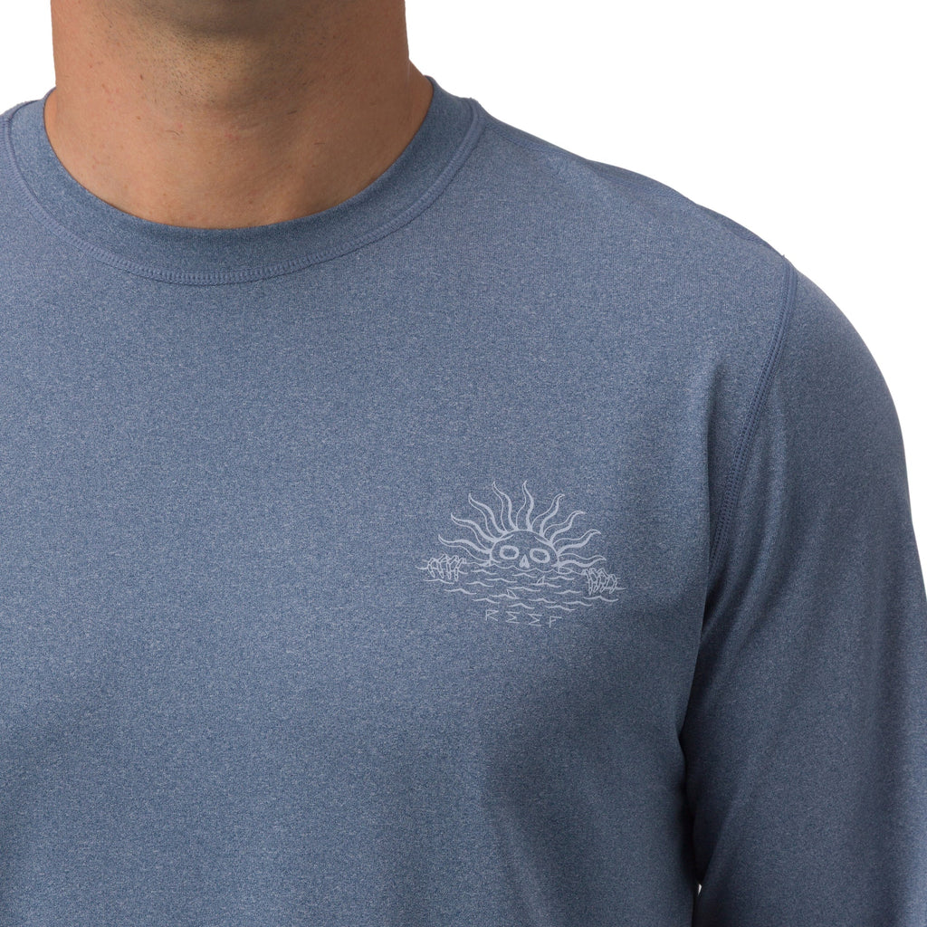 Men’s Set In Performance Shirt in blue with subtle sun and waves graphic on chest, highlighting comfort and durability.