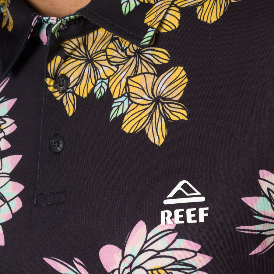 Close-up of the upper front of the Wesland Polo showing floral print and REEF logo on a men’s surf-inspired shirt.