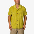 Man wearing a mustard yellow Myran Camp Shirt with short sleeves and vertical stripes, front pocket visible, standing straight.