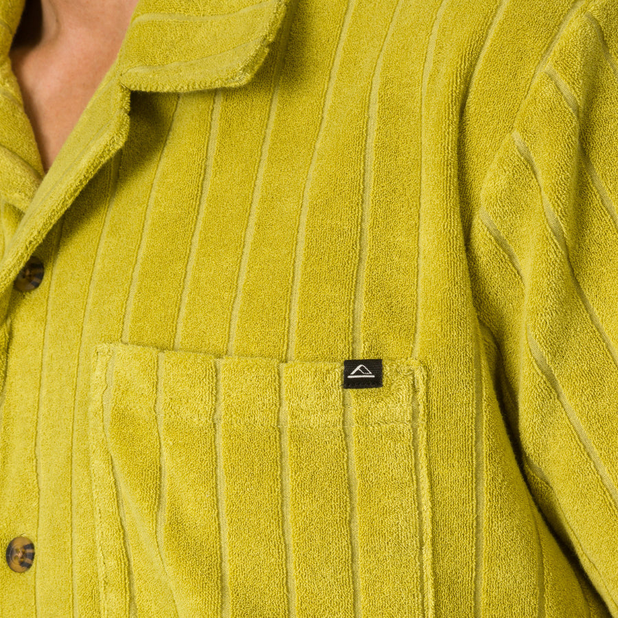 Close-up of the chest pocket and collar on the men's Myran Camp Shirt in textured green fabric with vertical stripes.