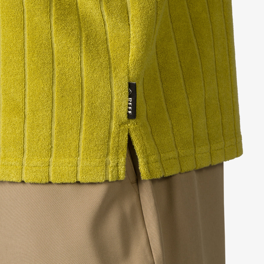 Close-up of the hem and side slit of the Myran Camp Shirt in olive green, highlighting textured ribbed fabric.