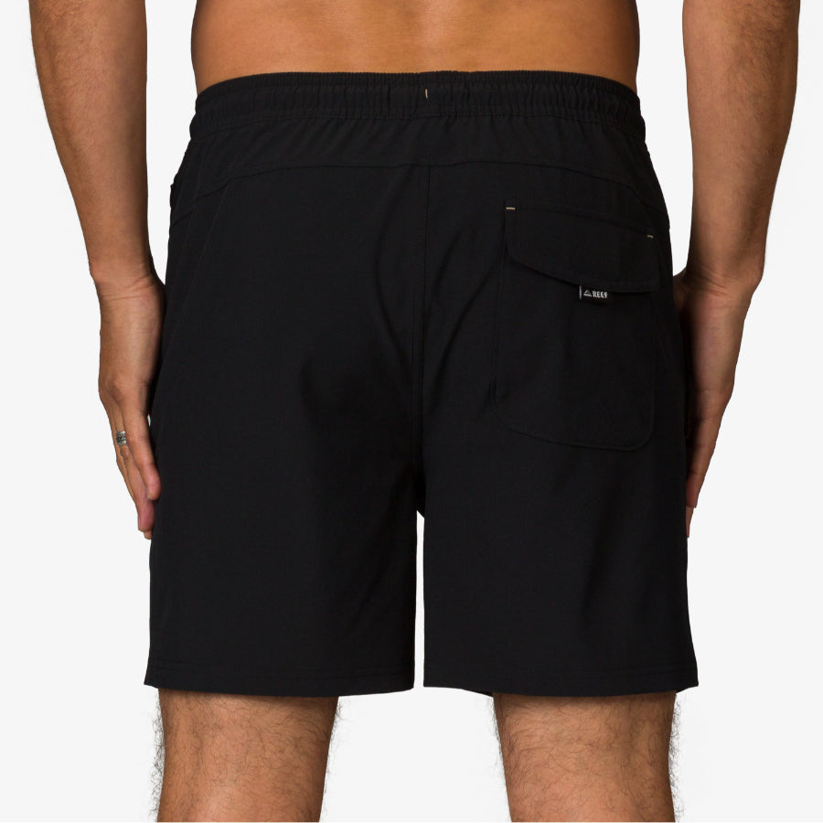 Rear view of men’s Rushmore Hybrid Short in black, showing back pocket and elastic waistband, beach-inspired comfort apparel.