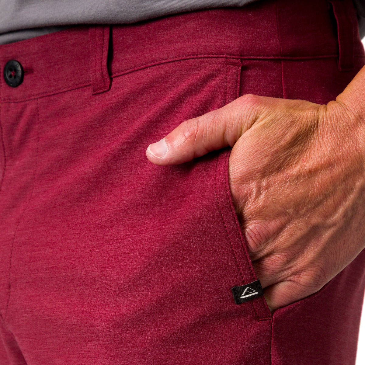 Close-up of the left front pocket and waistband of red Destro Hybrid Short worn by a man, emphasizing comfort and style.
