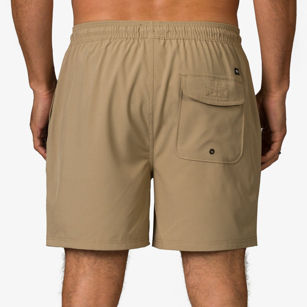 Back view of men's Garland Hybrid Short in tan with rear pocket, elastic waistband, and beach-ready comfort design.