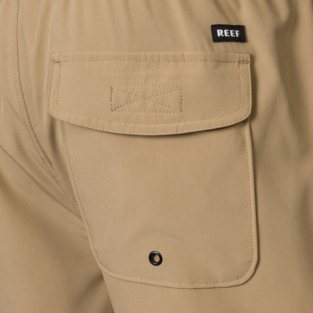 Close-up of the back pocket on the men's Garland Hybrid Short in tan, featuring durable stitching and REEF tag.
