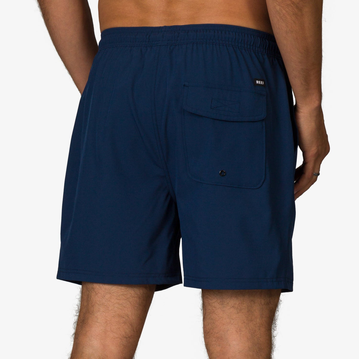 Back view of men's Garland Hybrid Short in navy, featuring a pocket with flap and button closure, beach-inspired comfort.