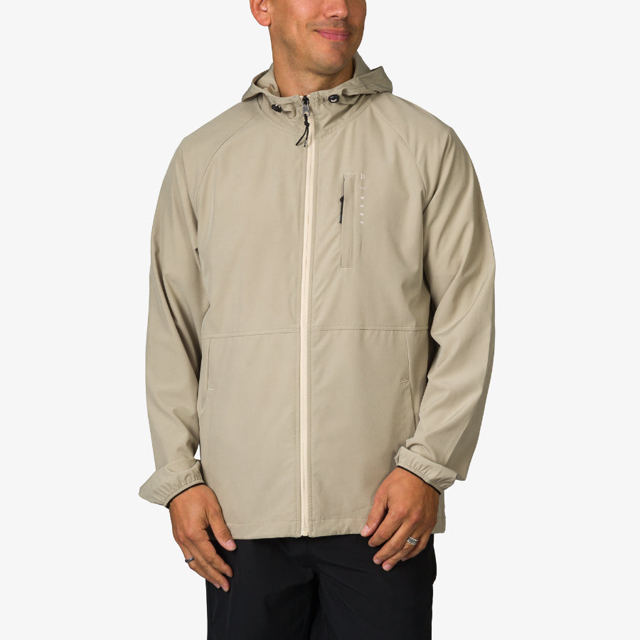 Man wearing beige Garvey Jacket facing front with hood, lightweight and durable beach-inspired men's apparel.