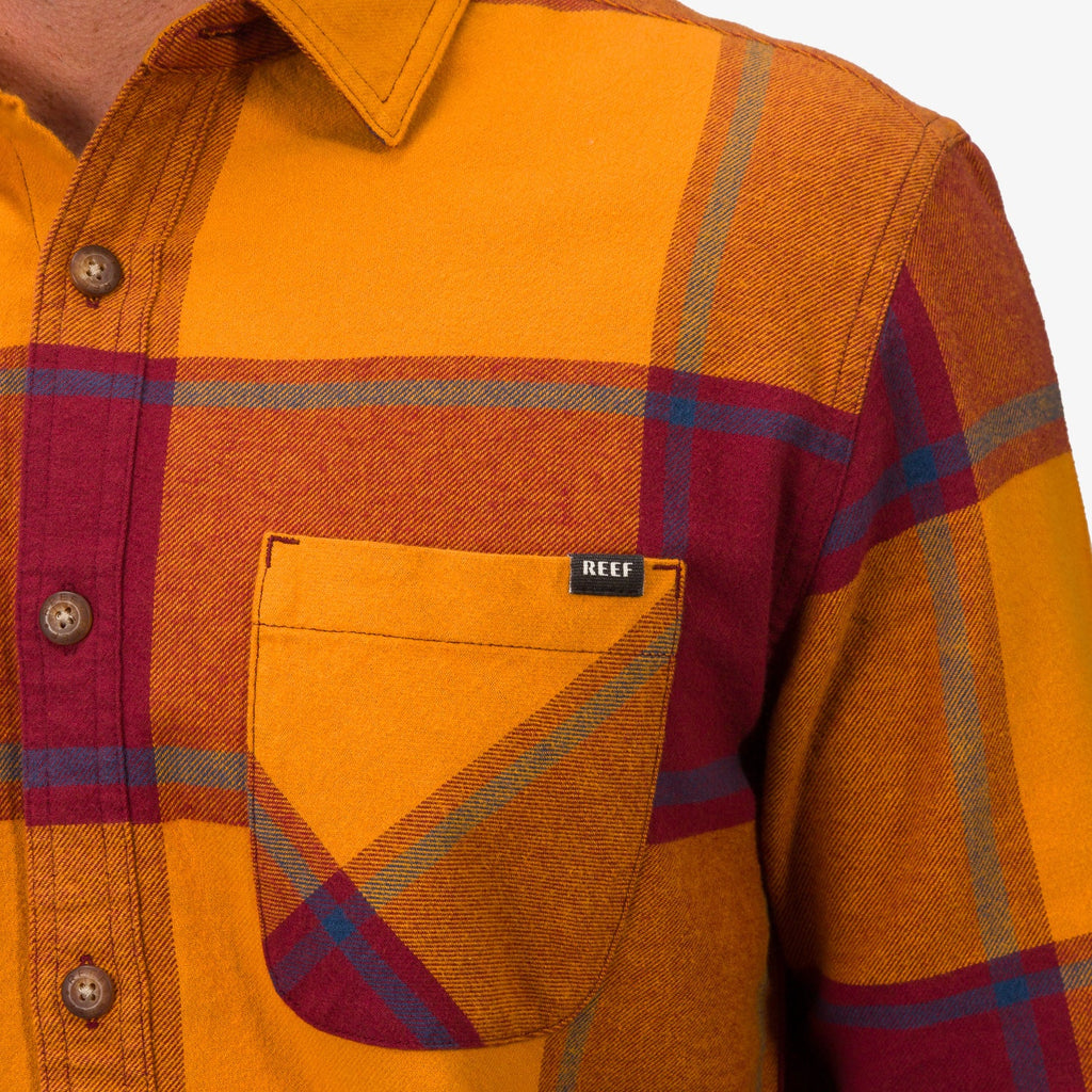 Close-up of the chest pocket on the Morris Ls Wvn Shirt showcasing orange and red plaid pattern with REEF tag.