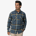 Man wearing a blue plaid Dyson Flannel Shirt with front pockets, modeled for casual beach-inspired comfort apparel.