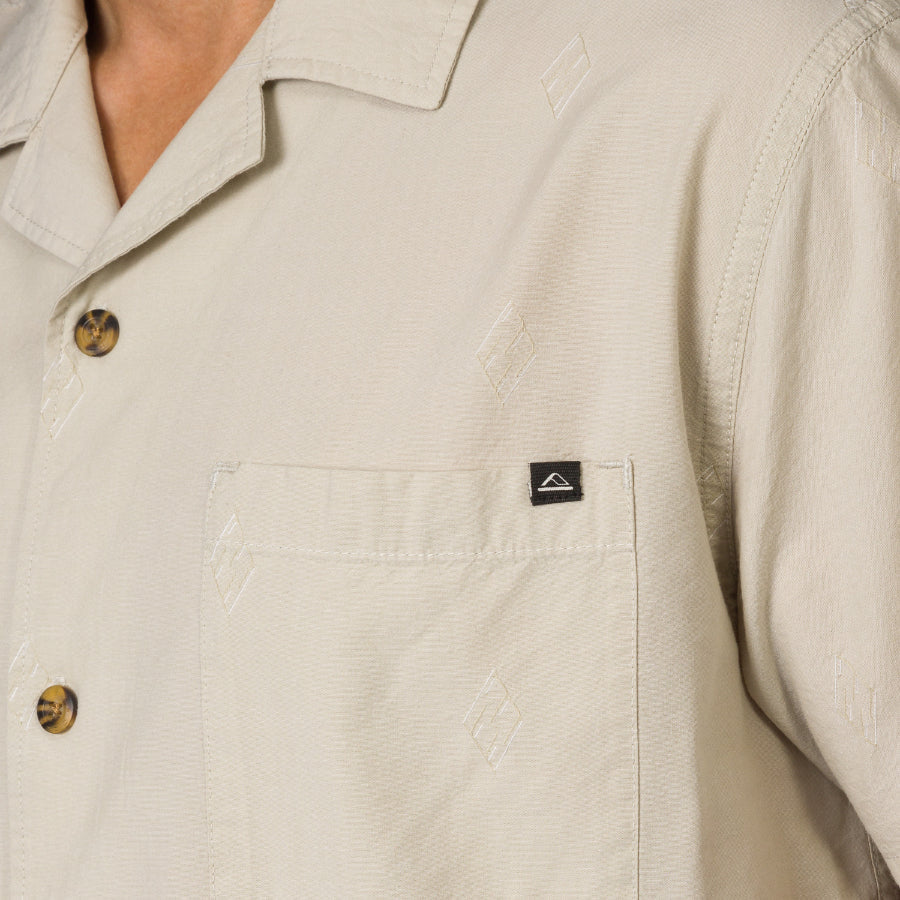 Close-up of the beige Harold Camp Shirt pocket and upper chest showing subtle pattern and tortoiseshell buttons.