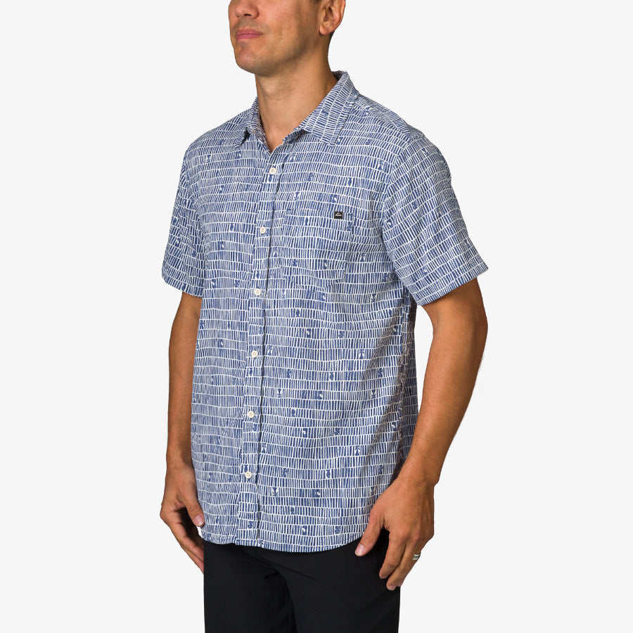 Man wearing a blue patterned Ferris Classic Shirt standing with arms relaxed, beach-inspired comfort and casual style.