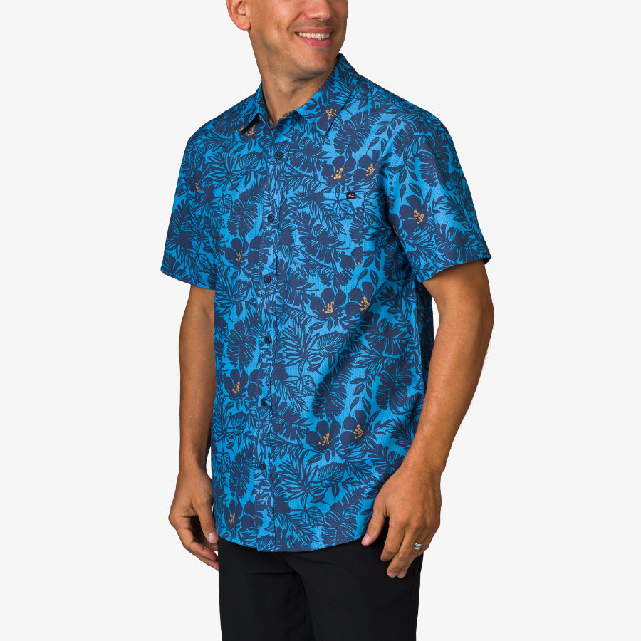 Man wearing a blue floral Tyson Classic Shirt facing left, showcasing beach-inspired, comfortable men's apparel.
