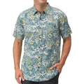 Man wearing a blue and yellow floral patterned short-sleeve Eugene Woven Shirt, front view with hand in pocket.