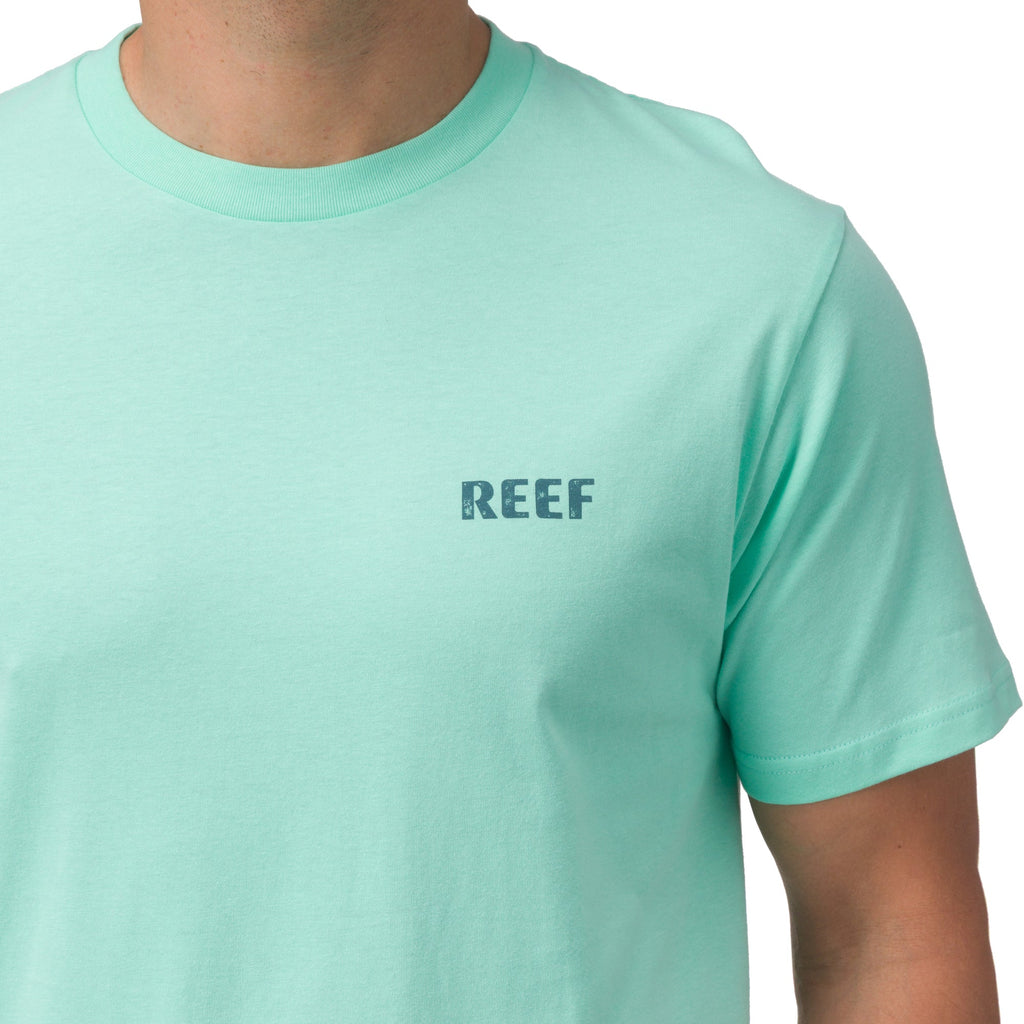 Close-up of the chest area of the Wellie Too Tee in soft aqua with REEF logo, offering beach-inspired comfort and style.
