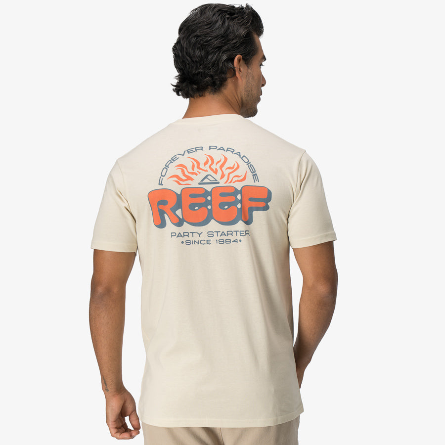 Man wearing the back view of the Quinn Tee with a colorful REEF logo and beach-inspired graphic in cream color