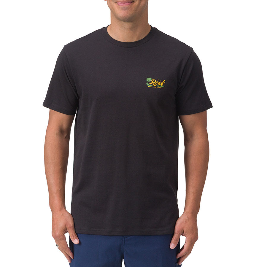 Front view of a man wearing a black Isac Tee with small yellow Reef logo, beach-inspired men's apparel for everyday comfort.