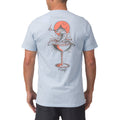 Man wearing a light blue Marlinrita Tee showing back with fish cocktail graphic, surf-inspired comfort apparel