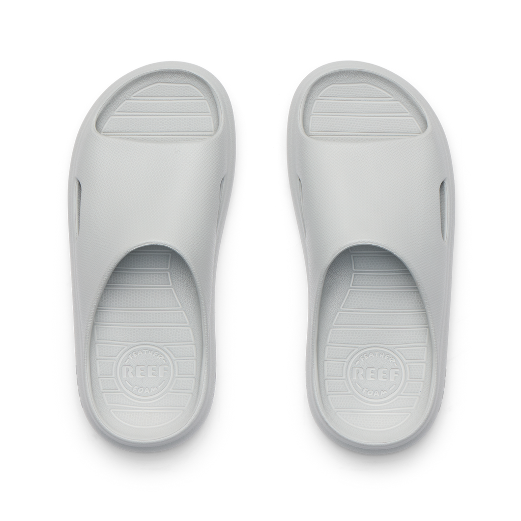 Kids Rio Slide sandals in light grey, top view showing open toe and cushioned, water-friendly design facing upward.