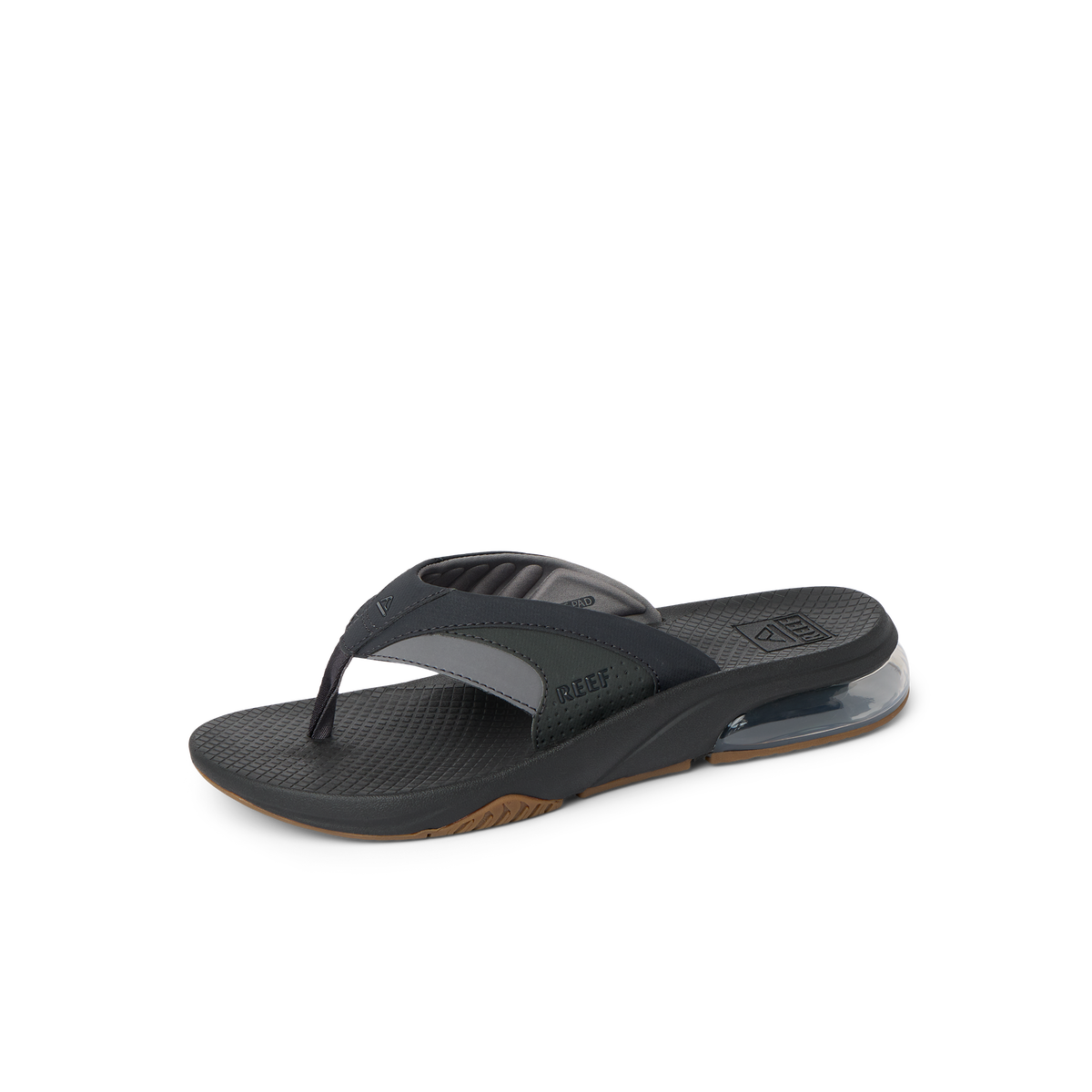 Fanning + men’s black and gum flip flop facing right, close-up of padded toe post and cushioned arch support.
