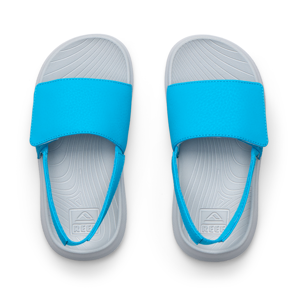 Top view of Little Salty Slide sandals for boys showing blue straps, grey molded footbeds with arch support and soft cushioning.