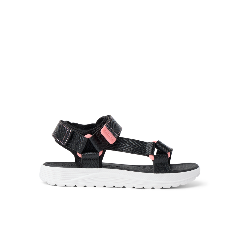 Kids Shoremazing sandal for girls facing right, featuring black straps with pink accents and cushioned white sole.