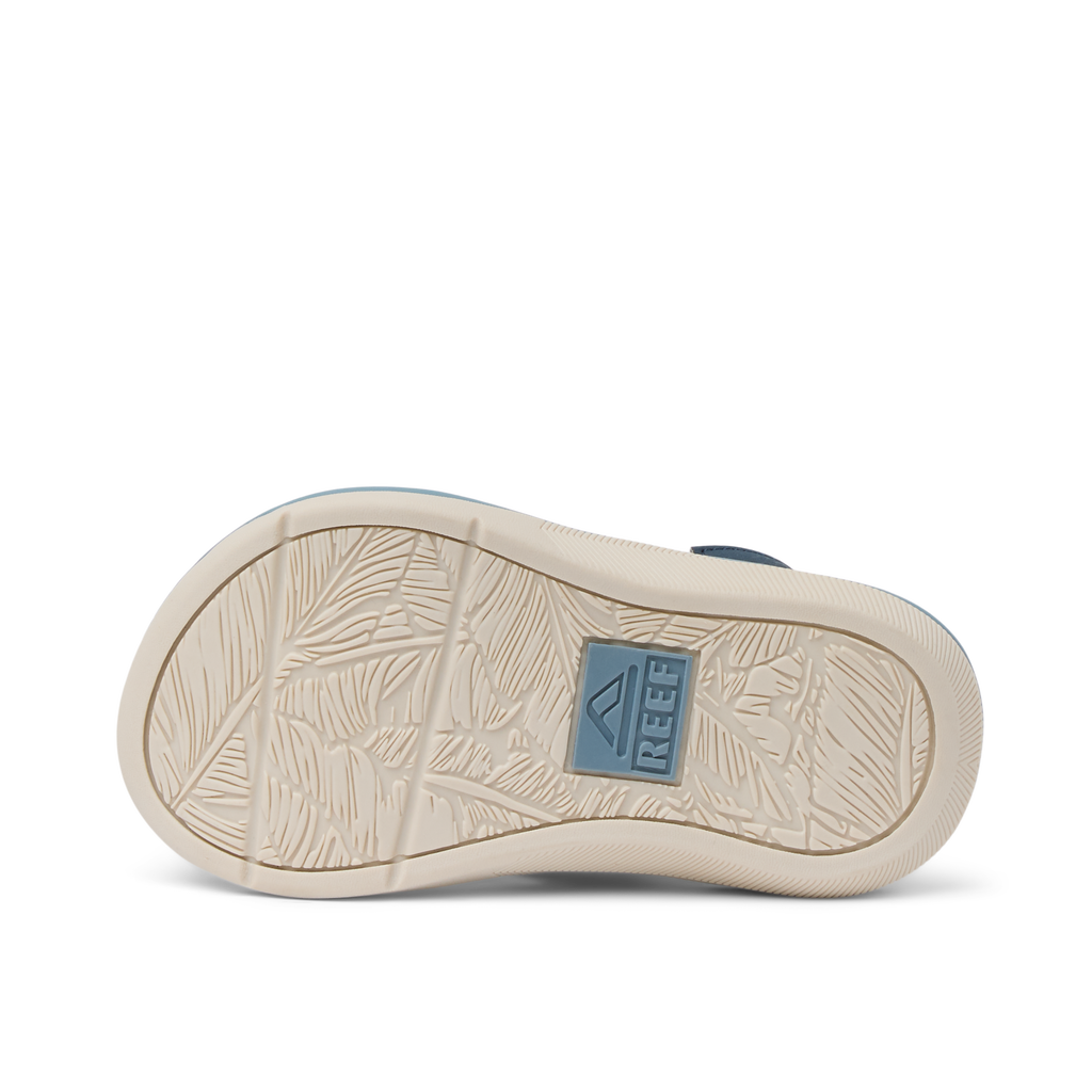 Sole of Little Santa Ana boys shoe facing up, showing durable, water-friendly outsole with Reef logo and leaf pattern.