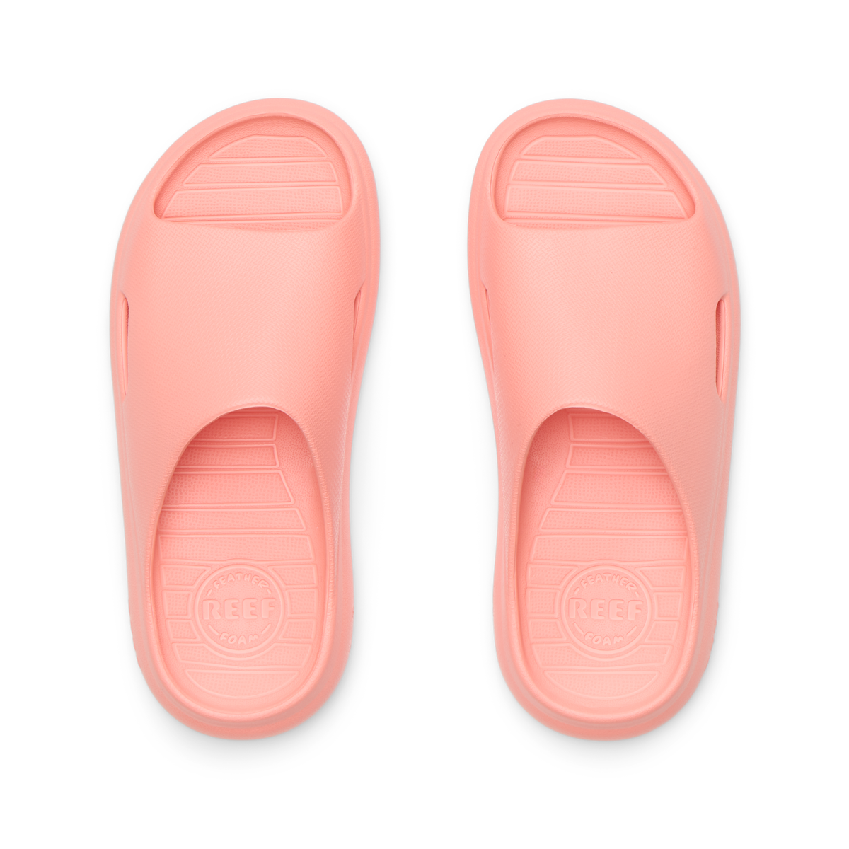 Top view of coral Kids Rio Slide unisex sandals showing molded footbed and soft-rebound cushioning for beach comfort