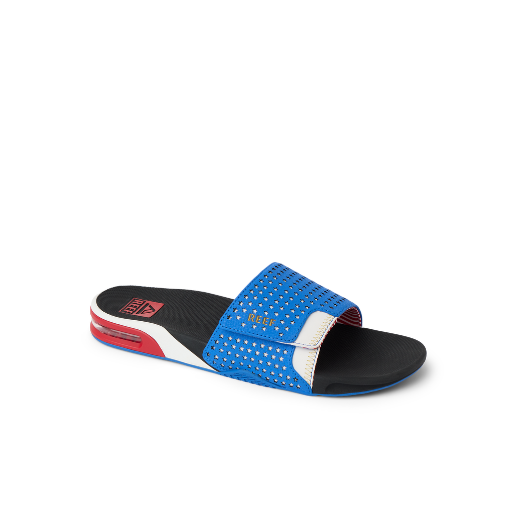 Fanning Slide facing right, close-up of breathable blue upper with cushioned sole, surf-inspired slide for men’s beach comfort.