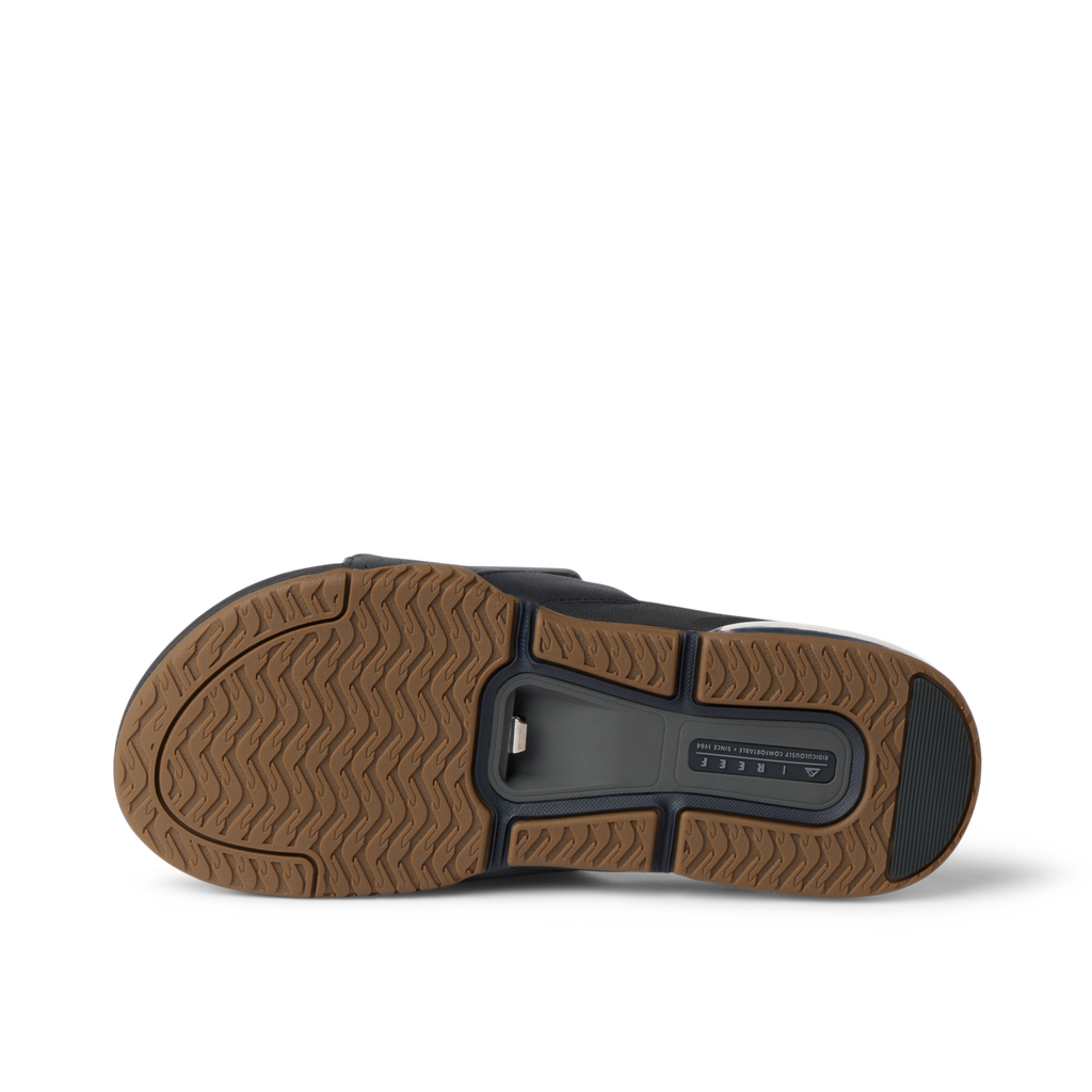 Fanning + Slide sandal sole facing up, showing brown textured tread and black oversized airbag heel for cushion comfort