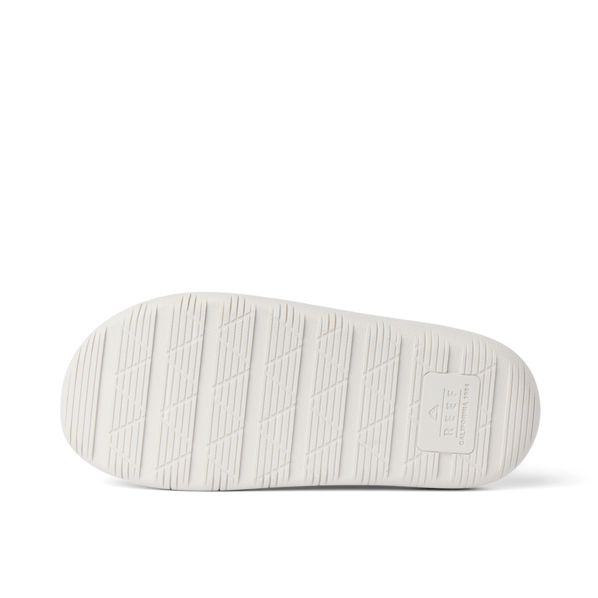 Rambler Kicker sandal sole facing up in off-white with textured grip and REEF logo for durable lightweight comfort and traction