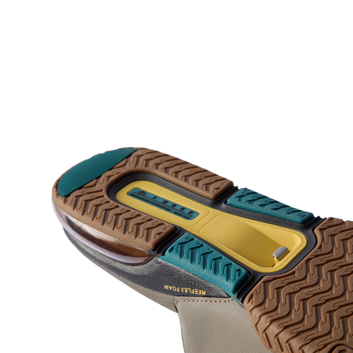 Close-up of slide sole facing upward showing multi-textured tread, REEFLEX foam cushioning, and blue and tan rubber grip sections