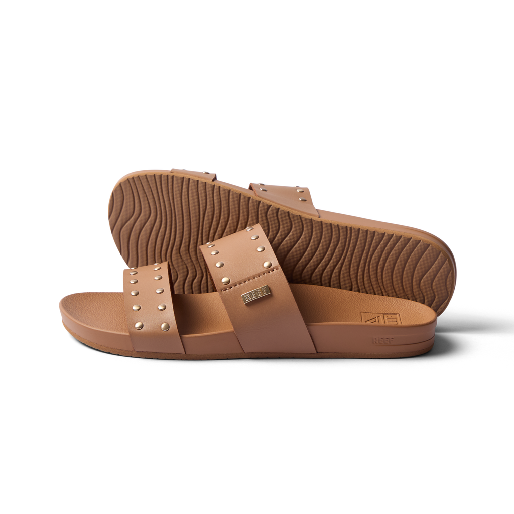 Side view of women's Cushion Vista sandals in tan with stud accents, showing soft footbed and durable outsole for beach comfort.