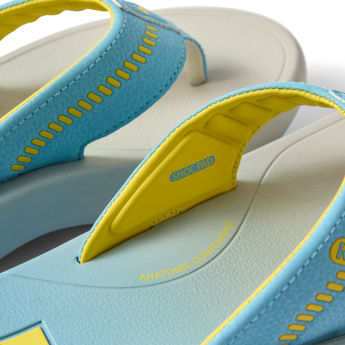 Close-up of Cruiser men's blue and yellow surf-inspired flip flops showing anatomical arch support and shock pad features facing right.