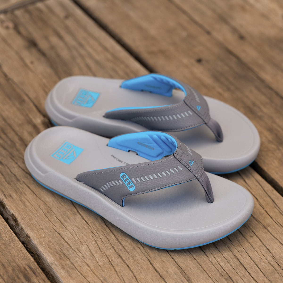 Pair of Cruiser men's grey and aqua sandals facing right, showing top and inner side with cushioned straps and arch support.