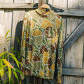 Men's Bamboo Lightweight Hoodie - Floral Camo hanging on wooden fence, lightweight breathable fabric, surf-inspired comfort design