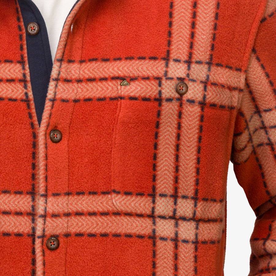 Close-up of the chest area of a men's Karter Shirt Jacket in orange plaid, showcasing comfort and surf-inspired design.