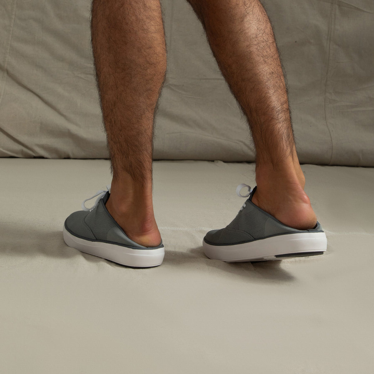 Rear view of men's Neptune Lido grey sneakers worn as slip-ons, showing soft cushioning and durable outsole for beach comfort.