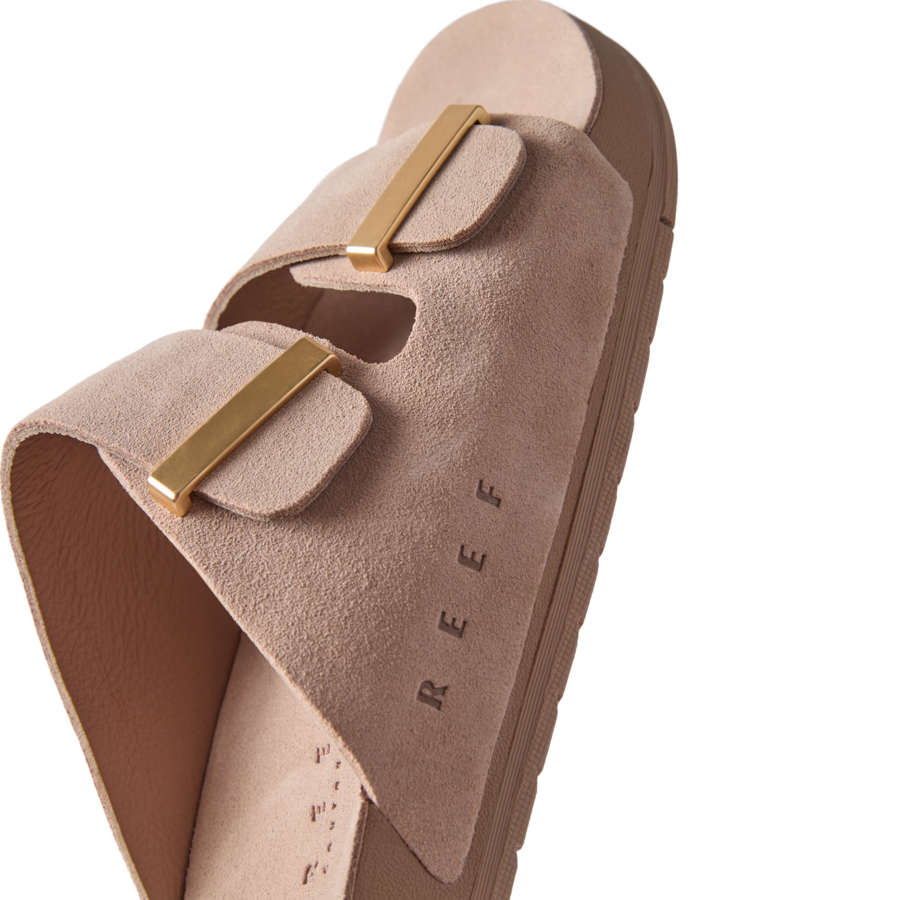 Ojai Two Bar women's sandal facing right, close-up on soft taupe suede upper with gold-tone buckles and embossed REEF logo