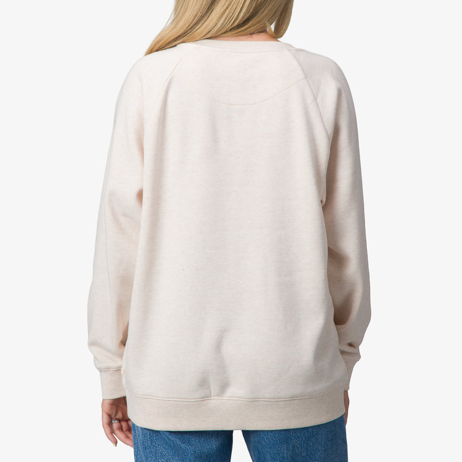 Back view of a woman wearing Oversized Raglan Fleece in oatmeal heather, showcasing comfort and surf-inspired casual style.