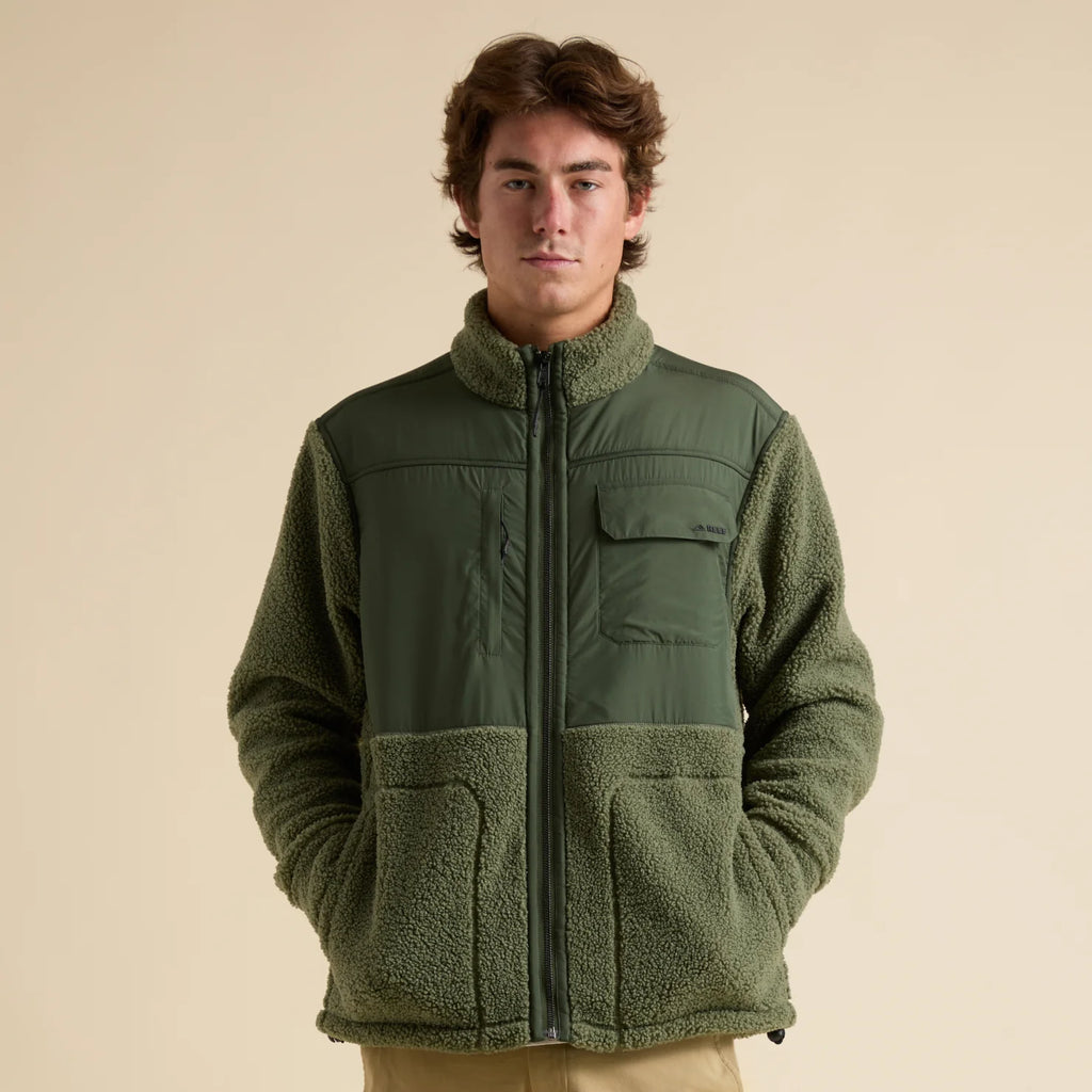 Front-facing view of a man wearing the Cooke Sherpa Jacket in olive green, showcasing comfort and beach-inspired style.