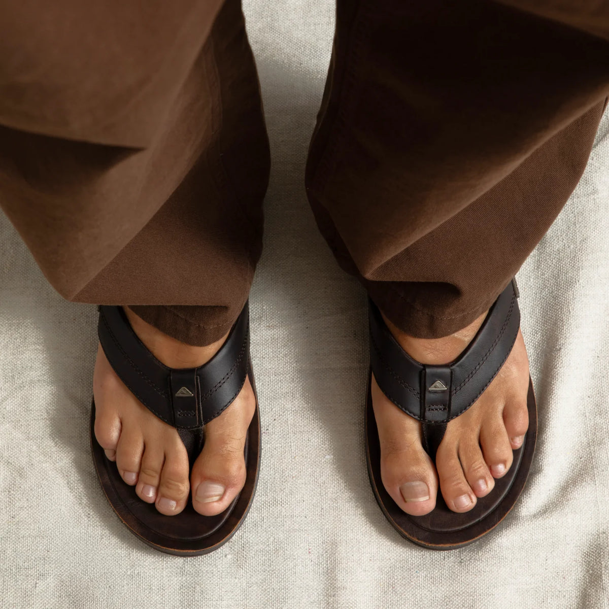Top view of men's Leather Offshore brown leather sandals on feet, showing comfort-focused design and anatomical arch support.