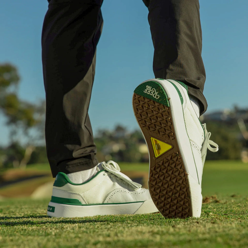 Onshore Pebble sneaker facing backward showing sole with arch support, beach-inspired durable white and green men's shoes
