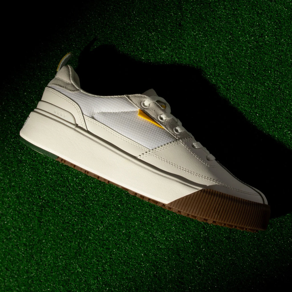 Onshore Pines men's white sneaker left side profile, lightweight and comfort-focused with gum sole on green surface.