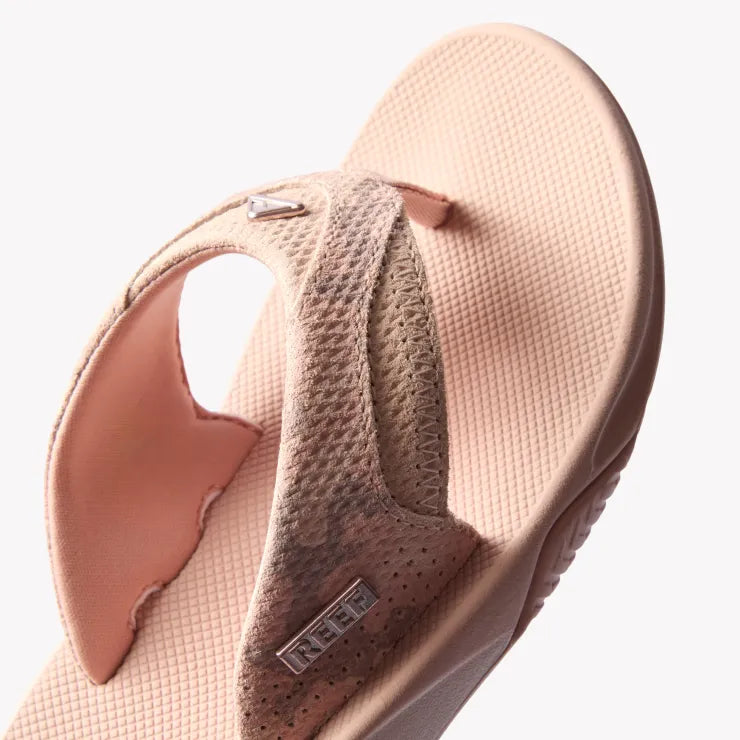 Fanning sandal facing left, close-up of textured soft suede strap and cushioned footbed, arch support visible.