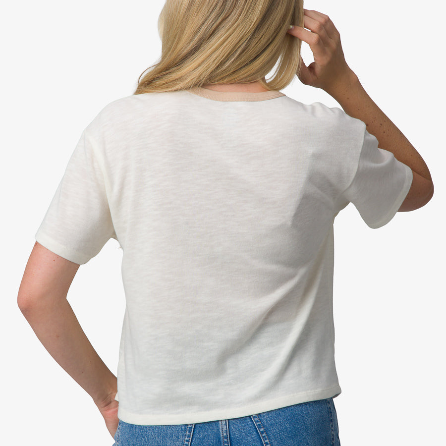Woman wearing the back view of a white Ringer Tee with a relaxed fit, designed for beach-inspired comfort and style.