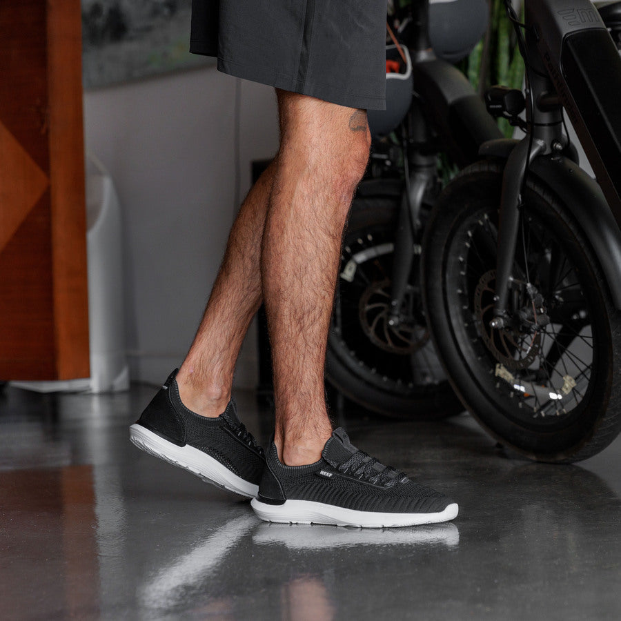 Valle black men's sneaker facing left, close-up of side and sole, lightweight with anatomical arch support.