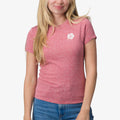 Woman wearing a mauve Saylor Fitted Tee with a small white hibiscus logo on chest, front view, beach-inspired comfort apparel.