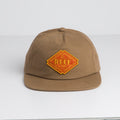 Front view of Stafford Ripstop Hat in brown with yellow REEF embroidered patch, surf-inspired comfort design.