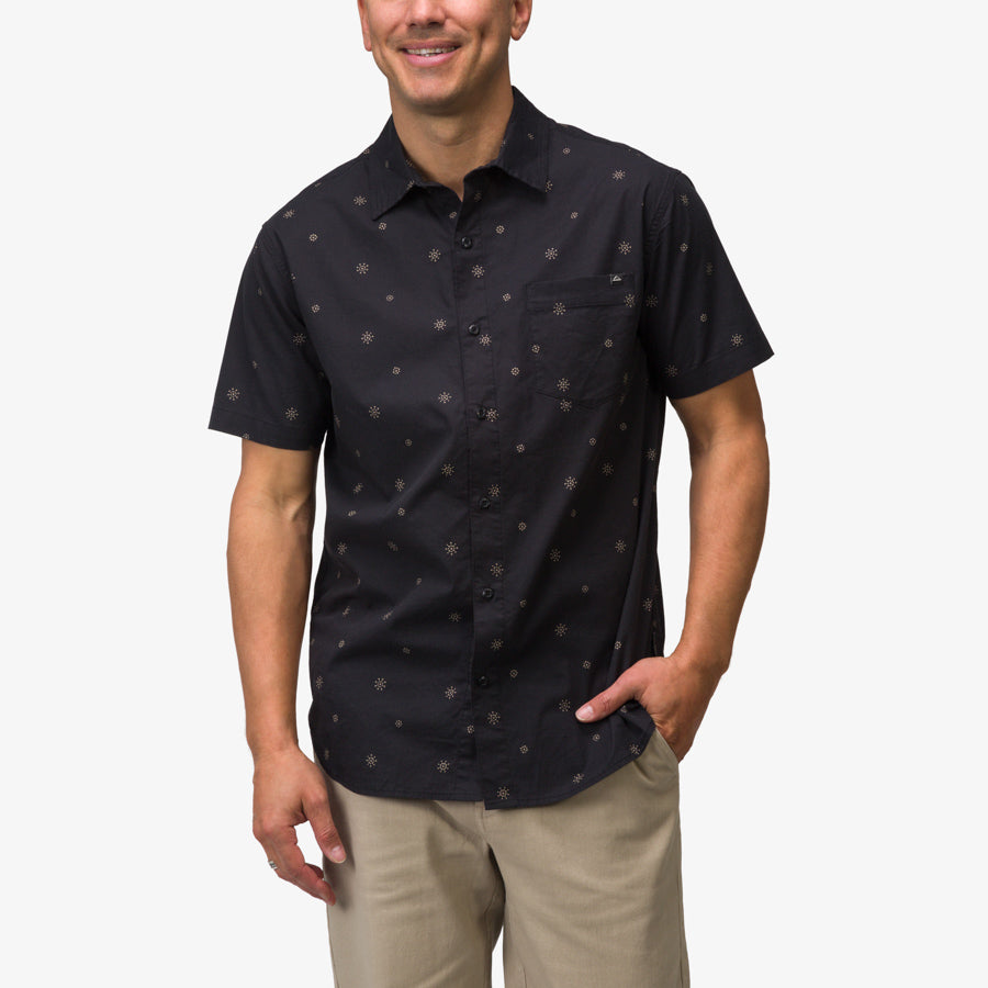 Man wearing a black Topaz Shirt with subtle pattern, styled casually for beach and active lifestyles, front view.